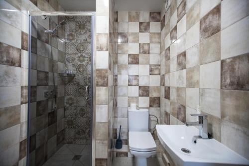 a bathroom with a toilet and a shower and a sink at Solo Apartment Kamenskaya in Kyiv