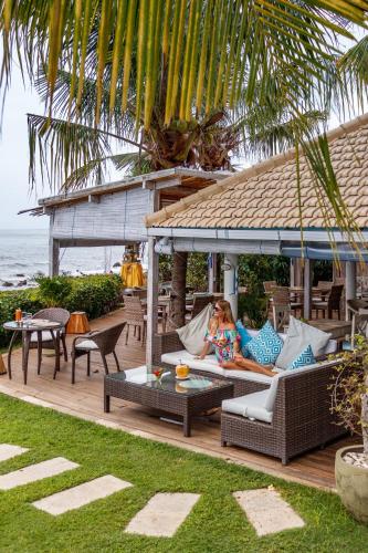 a woman is laying on a couch on a patio at Mayo Resort in Umeanyar