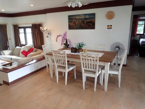 a living room with a table and chairs and a couch at Rock Garden E28 4 bedroom Pool villa in Mae Pim