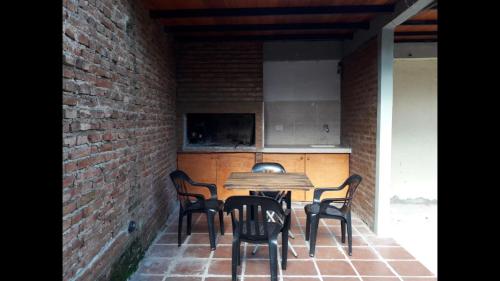 Duplex en Valle Hermoso في فالي هيرموسو: مطبخ مع طاولة وكراسي في جدار من الطوب