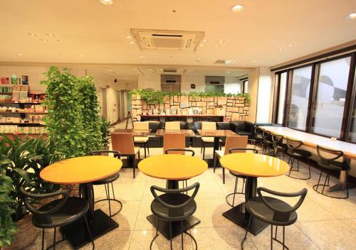 a restaurant with tables and chairs in a library at Urban Hotel Kyoto in Kyoto