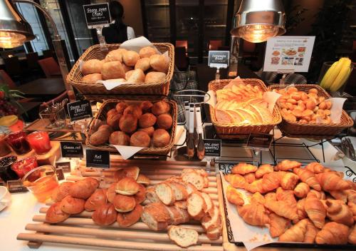 a display case with many different types of bread and pastries at Urban Hotel Kyoto in Kyoto