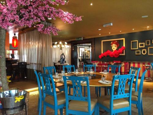 Hotel Mimosa في ميلاكا: غرفة طعام مع طاولة وكراسي زرقاء