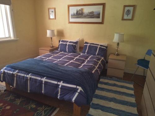 a bedroom with a bed with blue comforter and pillows at Crystal Springs Holiday Accommodation in Walpole