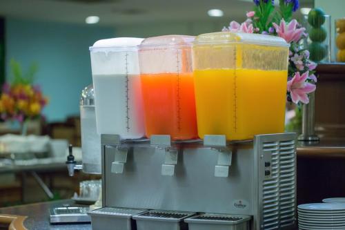 three containers of juice sitting on top of a counter at Asia Cha-am Hotel in Cha Am