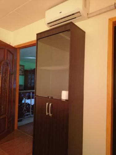 a wooden cabinet with a mirror in a room at Vievan's transient house in Alaminos