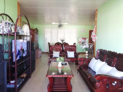 a living room with leather couches and a tv at Vievan's transient house in Alaminos