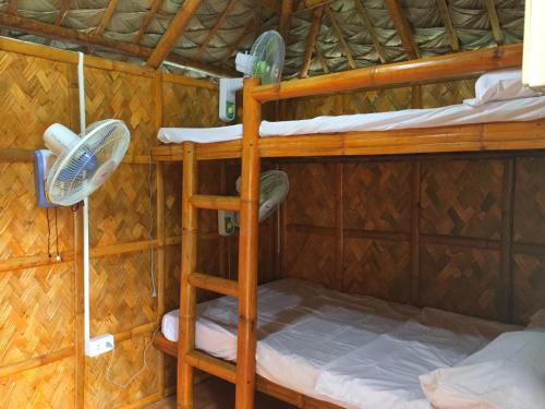 a room with two bunk beds and a fan at SeaLovers' Place Masasa Beach in Batangas City