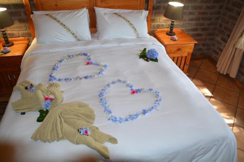 a bed with hearts made out of flowers on it at Thaba Tsweni Lodge & Safaris in Graskop