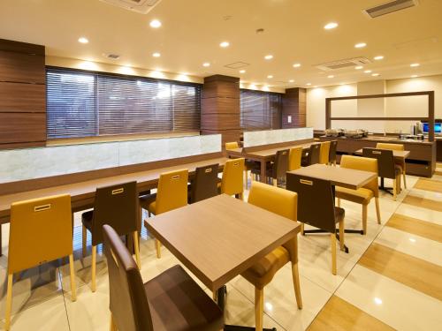 a restaurant with tables and chairs and a counter at Super Hotel Mihara Ekimae in Mihara