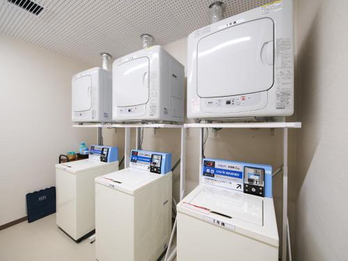 a laboratory with four machines and acomputer on a shelf at Super Hotel Mihara Ekimae in Mihara