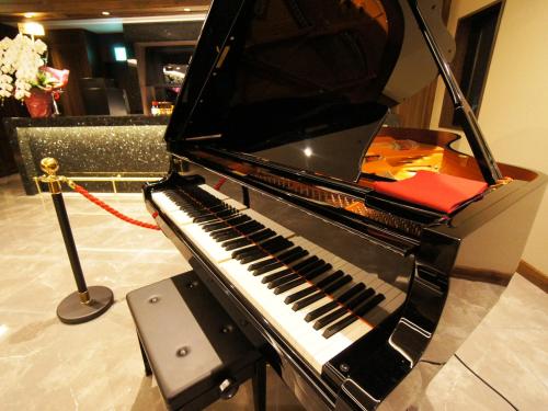 a piano sitting on display in a room at Hotel Abest Grande Okayama in Okayama