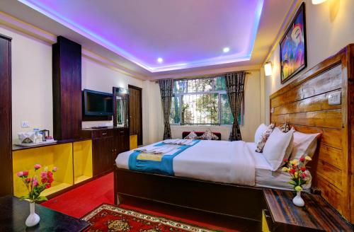 a bedroom with a large bed and a window at Golden Dolma in Darjeeling