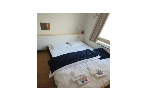 a small bedroom with two beds and a window at Nagoya - Hotel / Vacation STAY 13460 in Nagoya