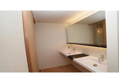 uma casa de banho com 2 lavatórios e um espelho em Nagoya Hostel The Three Smiles / Vacation STAY 13457 em Nagoia