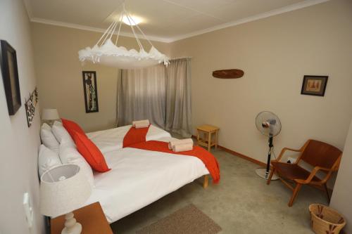 a bedroom with a large white bed with red pillows at Orange House Self Catering in Aus