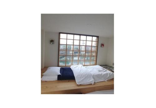 a bedroom with a bed and a window at Nagoya Hostel The Three Smiles / Vacation STAY 13462 in Nagoya