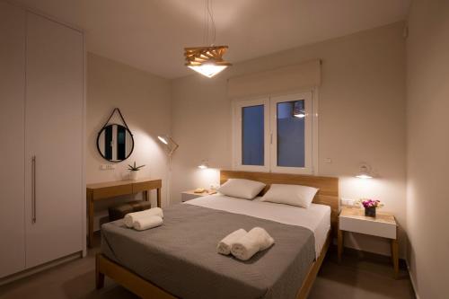 a bedroom with a bed with two towels on it at Sea La Vie in Adelianos Kampos