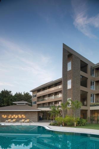 an exterior view of a hotel with a swimming pool at Kabir Hotel & Spa in Vadodara