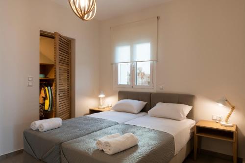 a bedroom with two beds with towels on them at Sea La Vie in Adelianos Kampos