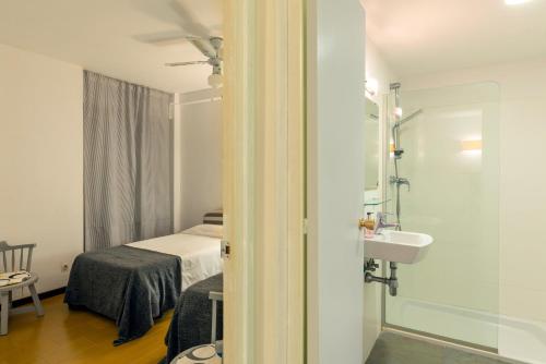 a bathroom with a bed and a sink in a room at Edificio Tropicana in Tossa de Mar