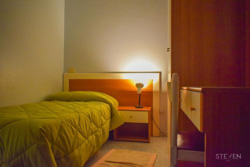 a bedroom with a bed and a desk with a lamp at Hotel Ristorante Mommo in Polistena