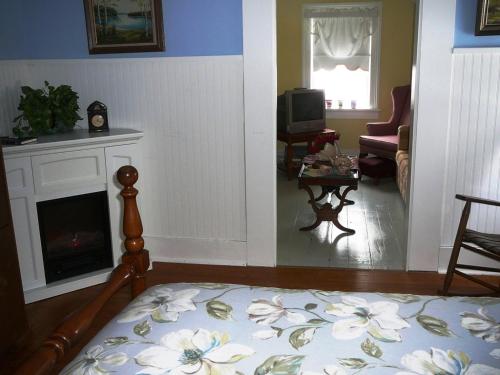 a living room with a bed and a fireplace at Gables Bed & Breakfast in Stayner