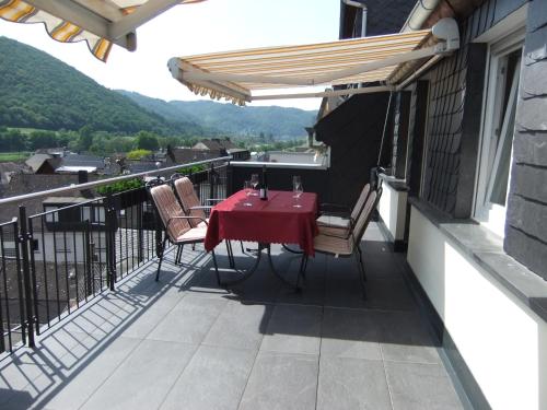 a patio with a table and chairs on a balcony at Ferienwohnung Morgen in Valwig