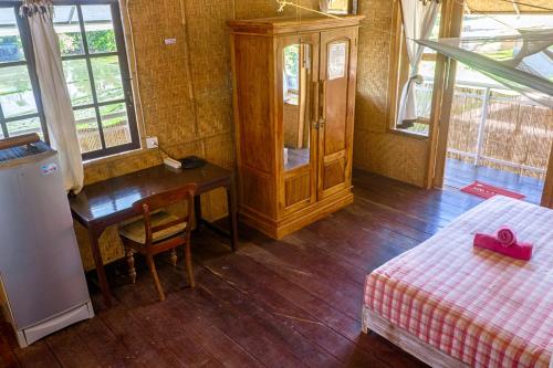 a bedroom with a desk and a bed and a table at Kris Kos in Canggu