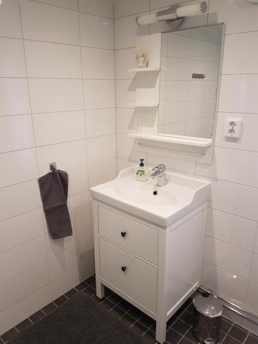 bagno bianco con lavandino e specchio di Hedesunda Bed & Breakfast a Hedesunda