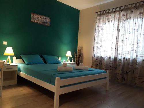 a green bedroom with a bed with a teddy bear on it at Vila & Apartments MATEA in Gevgelija