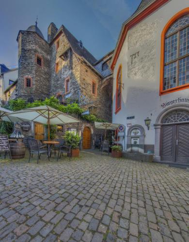 a courtyard with tables and chairs in front of a castle at Villa Beilstein in Beilstein