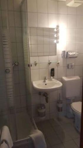 ein Bad mit einer Dusche, einem Waschbecken und einem WC in der Unterkunft Weingasthaus zum Fährhof in Winningen