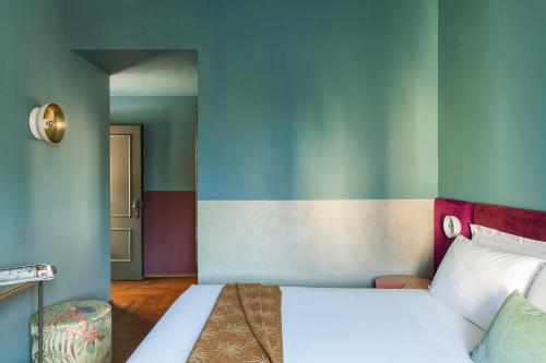 a bedroom with a white bed and a colorful wall at Condominio Monti Boutique Hotel in Rome