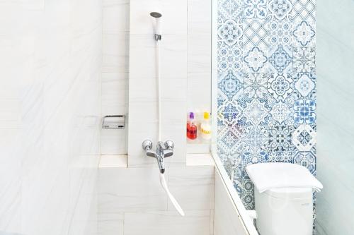 a white bathroom with a toilet and a shower at Hotel Wisata Niaga Campus in Purwokerto