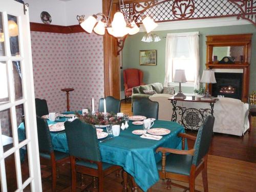 a dining room table with a blue table cloth and chairs at Gables Bed & Breakfast in Stayner