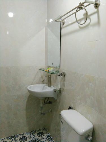 a white bathroom with a sink and a toilet at Nhà M&G in Da Lat