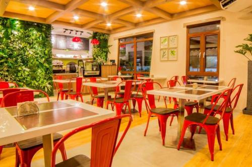 - un restaurant avec des tables et des chaises rouges dans une salle dans l'établissement Hotel Rosita, à Lucena