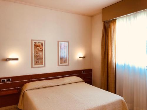 - une chambre avec un lit et une fenêtre dans l'établissement Hotel Delfina, à Signa