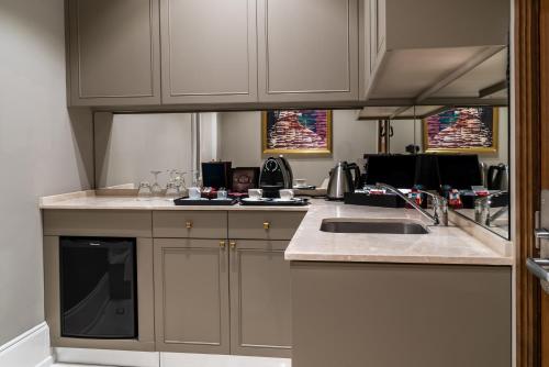 a kitchen with white cabinets and a counter top at Landmark Amman Hotel & Conference Center in Amman