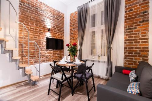 a living room with a table and a brick wall at DIETLA 99 APARTMENTS - IDEAL LOCATION - in the heart of Krakow in Kraków