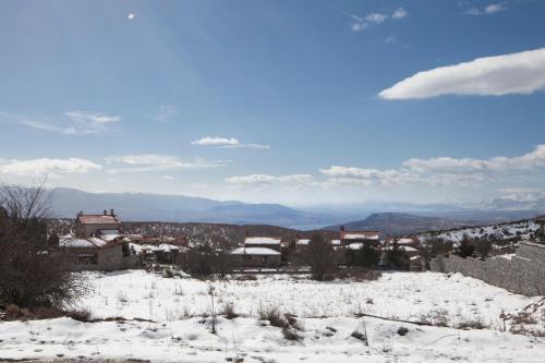 a town in the snow with mountains in the background at Villa Palaios Agios Athanasios in Palaios Agios Athanasios