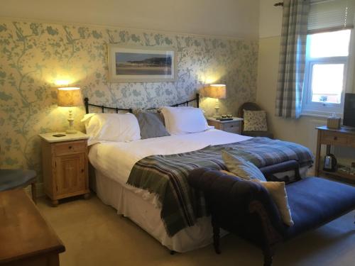 a bedroom with a large bed and a blue bench at Lee-Side B&B in Robin Hood's Bay