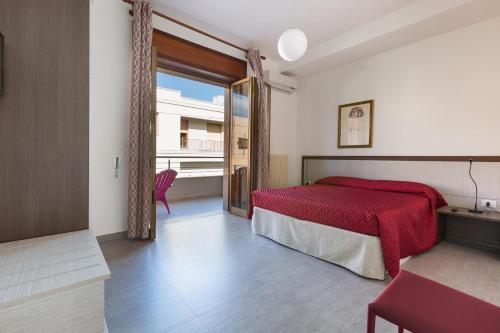 una camera con un letto rosso e una grande finestra di Versomare by BarbarHouse a Porto Cesareo