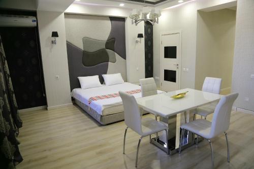 a bedroom with a bed and a table and chairs at Promenade Boutique Apartment in Bishkek