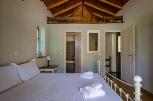 a bedroom with a bed with two towels on it at Picturesque Houses in Leonidio