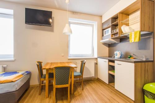 a small apartment with a table and a kitchen and a bed at Hotel Platan in Ostrów Wielkopolski