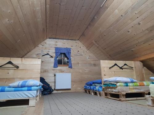 a room with two beds in a wooden room at Planinarski dom "Tornik" Zlatibor in Ribnica