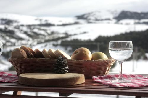 a basket of bread and a glass of wine on a table at Planinarski dom "Tornik" Zlatibor in Ribnica