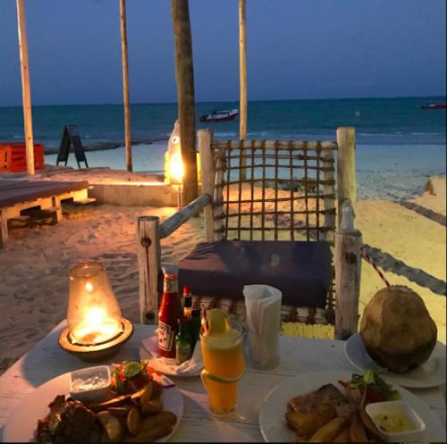 a table with food and drinks on the beach at Paje Beach Apartments & Hotel in Paje